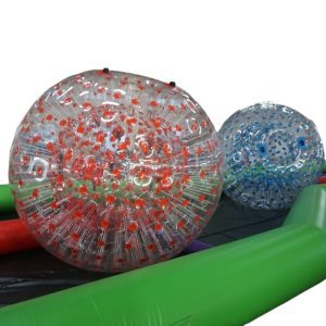 Le Zorbing Track est une course où les participants, enfermés dans de grandes boules transparentes, s'affrontent pour atteindre la ligne d'arrivée.