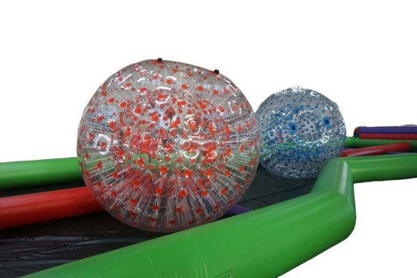 Le Zorbing Track est une course où les participants, enfermés dans de grandes boules transparentes, s'affrontent pour atteindre la ligne d'arrivée.