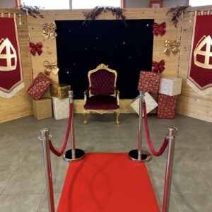 Un décor complet de Saint-Nicolas comprenant un fond en bois, un pendrillon lumineux, un trône majestueux, un tapis de cérémonie 3×1 m, six potelets, de faux cadeaux, diverses décorations pour créer une ambiance chaleureuse et féérique.  |Le Paradis De Tigrou